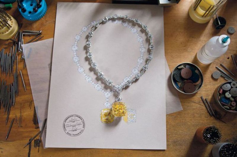 「The Tiffany Diamond」128.54克拉枕形明亮式切割黃鑽。電影《Breakfast at Tiffany’s第凡內早餐》(1961年),奧黛莉赫本在第五大道Tiffany & Co.精品店,吃甜甜圈喝咖啡,從櫥窗外望著裡頭的珠寶說著:「在那兒吃早餐不會不愉快!」劇情中出現的黃鑽緞帶項鍊,出自Tiffany設計師約翰史隆伯傑Jean Schlumberger之手,主石為紐約第五大道Tiffany總店的鎮店之寶。