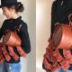 Look 4大波浪荷葉的袖子有著濃濃異國度假情懷,因為外套已經相當搶眼,包包就盡量選擇簡單俐落的輪廓,Marina選擇簡單的圓桶包做搭配,色系上也挑了和橘紅荷葉邊相近的駝色,讓造型上有所相呼應,並將包包以手拿方式取代肩背更為隨興