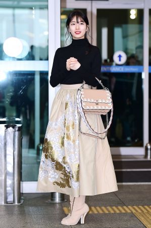 秀智同時間秀智也同樣出發米蘭,一身FENDI米色刺繡長裙、黑高領上衣搭配短靴,手上的FENDI最新包款Kan I選擇和裙子同色系的款式,甜美中帶點個性