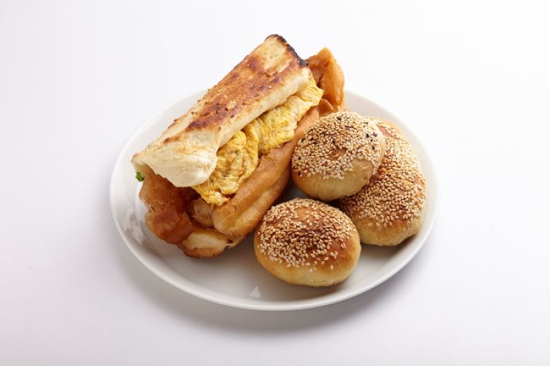 阜杭豆漿 人氣排隊早餐名物 人氣不墜排隊名店。炭火爐烤手工現揉蘿蔔絲餅、焦糖甜餅,燒餅夾入煎蛋皮與油條,鹹甜豆漿有炭燒香,誘發思古情懷。