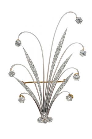 Tiffany 羽飾 (1890 - 1900) 黃金、鉑金與鑽石9.7 x 6.8 x 1.3 cm 由簇擁在中央的鑽石與向外四散的長條形葉片組成,背面配有胸針夾,底部配備螺絲裝置用於固定羽毛,這種髮飾稱為羽飾,靈感來自土耳其帝國風格頭飾中帶有羽毛的珠寶飾品。 羽飾於1890年至1981年的Blue Book中首度出現,廣受19至20世紀女性的喜愛,隨著這種風潮的流行,羽飾在世紀之交成為大熱門飾品,同時髮夾、冠飾和髮圈等新款髮飾也日益普及。 到了1908年,羽飾逐漸從Blue Book消失,取而代之的是髮帶與髮夾。隨著時尚風潮的變遷,原本用於固定頭髮的齒梳逐漸消失,轉變為胸針款式。