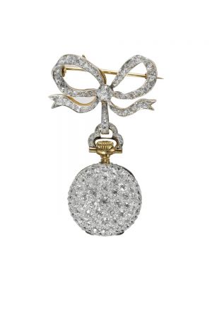 Tiffany胸針懷錶 Lapel Watch (1895 - 1917) 黃金、鉑金、鑽石、水晶與琺瑯5.3 x 3 x 1.2 cm佚名瑞士機芯 這款鋪鑲鑽石的女士懷錶,採用白色琺瑯錶盤與阿拉伯數字,搭配路易十五風格指針,並搭配一枚鑲嵌鑽石的胸針。胸針上的蝴蝶結造型展現Tiffany花環風格的典型特點:輕盈、靈動、柔美。 懷錶被認為是日常珠寶,女性經常將它們別在左肩下方。 這些懷錶是19世紀深受喜愛的高科技產品,如同當今最新款的iPhone一般備受世人追捧。Tiffany銷售多款女士時計,1895年的Blue Book就以3頁篇幅來展示不同的時計。Tiffany直至1917年才停止銷售胸針懷錶。