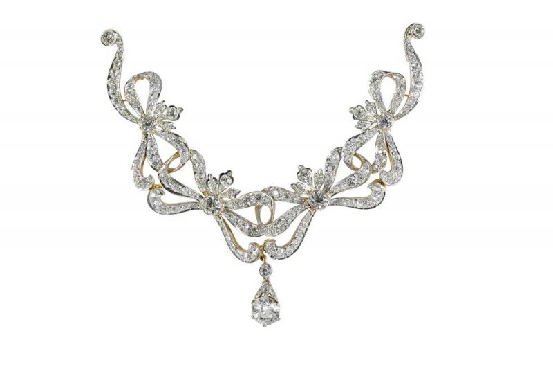 Tiffany緊身胸衣裝飾 (1909 - 1919)黃金、純銀、鉑金與鑽石8.2 x 9.6 x 0.7 cm這款胸針融合了經典花環元素、蝴蝶結以及鑽石,充分展現美國在鍍金時代對於單色鑽石珠寶的偏好。與之類似的多件作品均是當時公司產品目錄中最為昂貴的品項。設計資料顯示類似設計的產品收到了不同的尺寸需求,而主題上的變化更是多達數百種。大型胸針或緊身胸衣裝飾在19世紀末非常流行。佩戴在禮服上的緊身胸衣裝飾帶有多處鉸鍊設計,可以靈活轉動,而璀璨的鑽石即使在光線微弱的房間中也能綻放光芒。蝴蝶結和花簇是花環風格鑽石珠寶中最受歡迎的兩種圖案,盡顯奢華魅力與女性氣質。