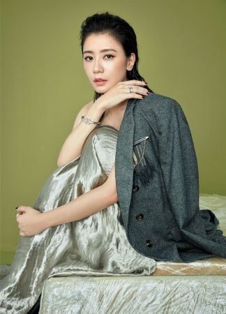 湖水綠金屬光澤長禮服,Bottega Veneta;胸章裝飾西裝外套,Brunello Cucinelli; Setting六爪鑲嵌鉑金鑽戒、3mm鉑金鑽石戒指、Embrace鉑金鑲鑽戒指、T Two 18K白金鑲鑽戒指,all by Tiffany。