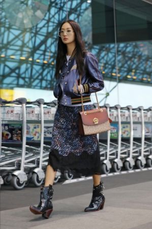 Varsity皮外套,NT45,800,Coach x Keith Haring。上衣,NT6,900,Coach x Keith Haring。刺繡蕾絲半身裙,NT20,800,Coach x Keith Haring。Signature C帆布印花Parker手袋,NT16,800。黑色皮短靴,NT23,800。